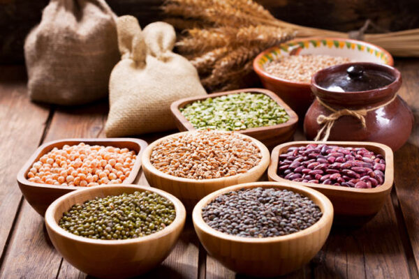 various cereals, seeds, beans and grains on wooden table